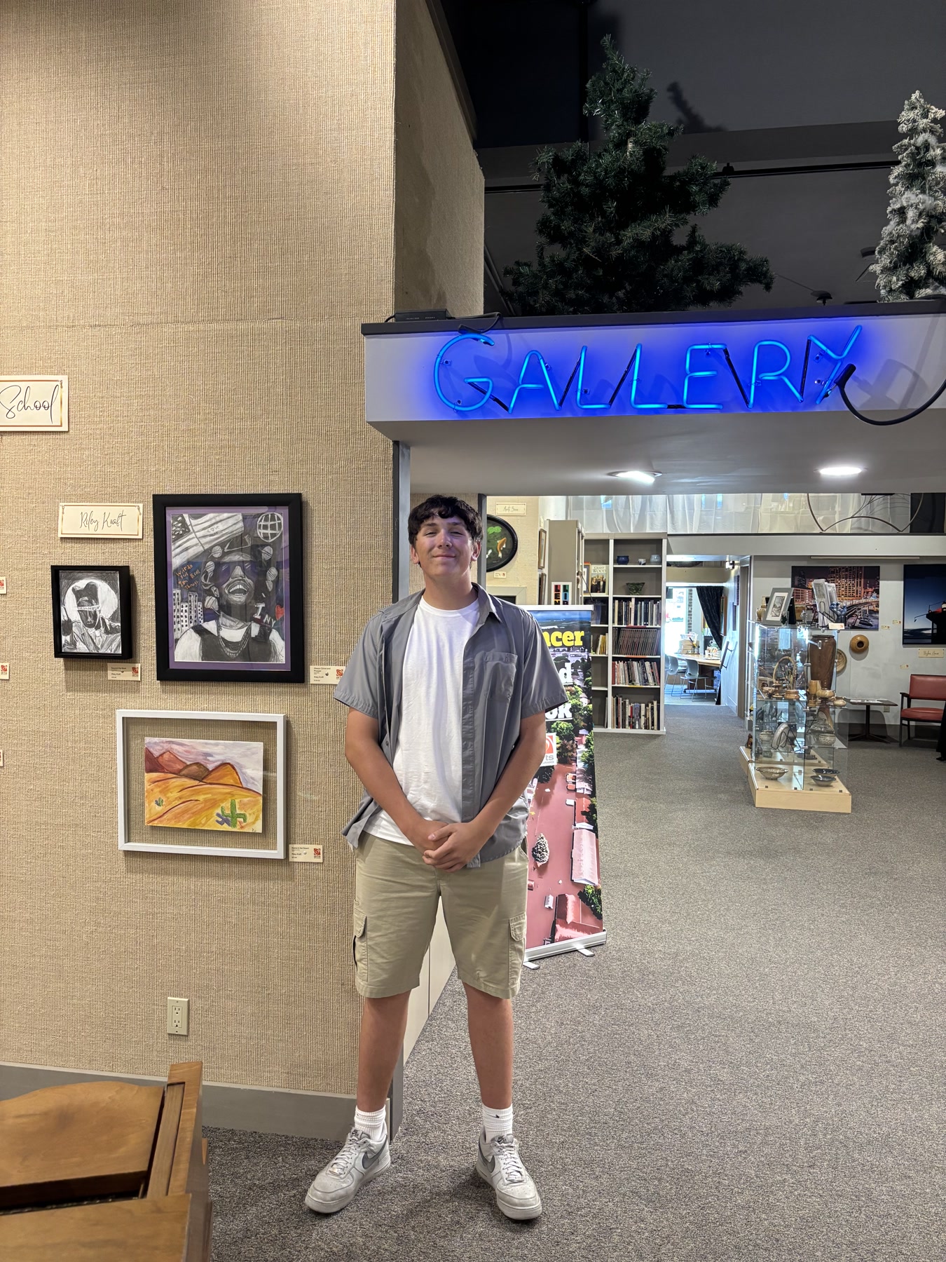 The Canvas Vault artist standing beside the exhibition display